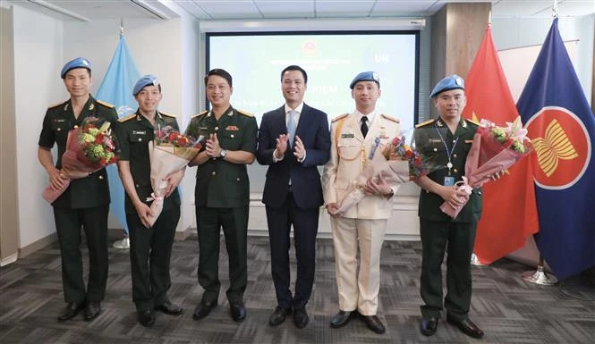 越南常驻联合国代表团团长邓黄江大使向联合国维和局的干部送花。