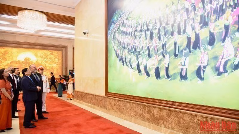 越南政府总理范明正向古巴总理曼努埃尔•马雷罗•克鲁斯介绍越南风土人情。