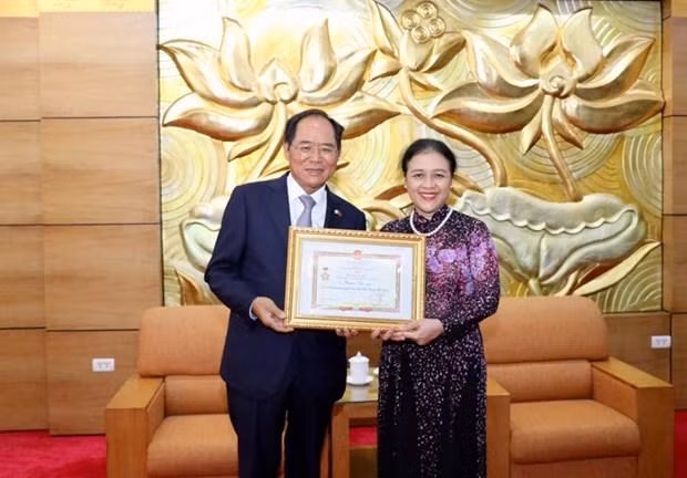 越南友好组织联合会主席阮芳娥向韩国驻越大使朴能运授予“致力于各民族间和平与友谊” 纪念章。