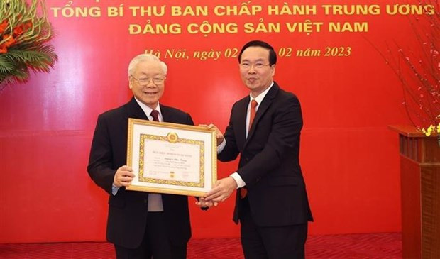越共中央书记处常务书记武文赏代表党领导向越共中央总书记阮富仲授予党龄55年徽章。（图片来源：越通社）