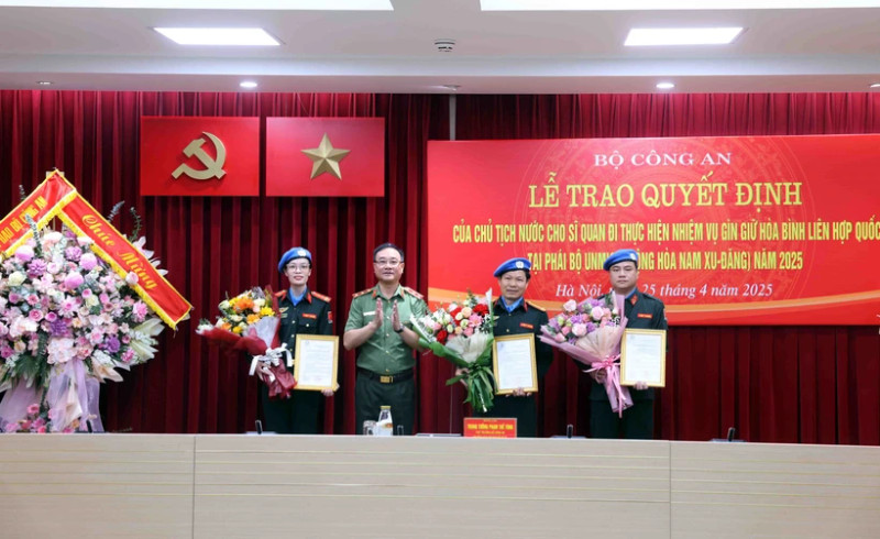 公安部副部长范世雄中将向2025年参与联合国南苏丹特派团的三名警官颁发国家主席的决定书。（图片来源：越通社）