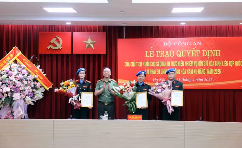 公安部副部长范世雄中将向2025年参与联合国南苏丹特派团的三名警官颁发国家主席的决定书。（图片来源：越通社）