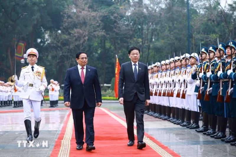 越南政府总理范明正与新加坡总理黄循财共同检阅仪仗队。（图片来源：越通社）