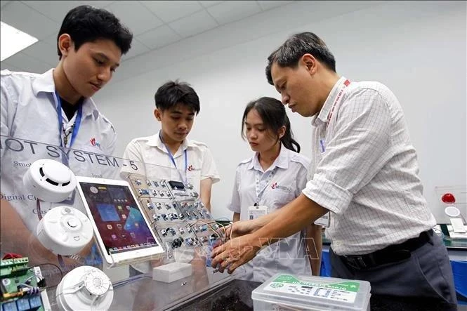 胡志明市工业大学电子技术学院教师引导学生学习和研究。（图片来源：越通社）