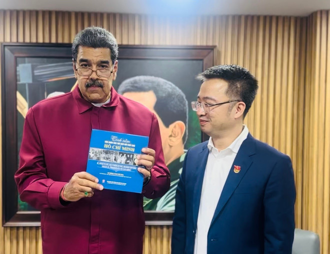 马杜罗总统接收由阮祥林赠送的《世界人民对胡志明主席的感情》（西班牙语版）书籍。（图片来源：越通社）