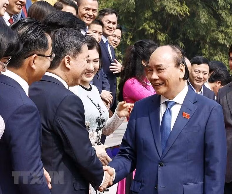 国家主席阮春福与模范青年企业家握手。