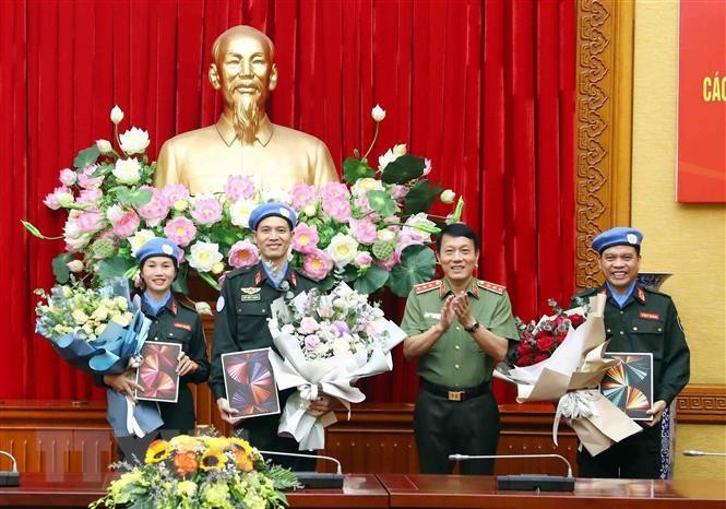 公安部副部长梁三光向参加联合国维和行动的人民公安军官赠送鲜花。