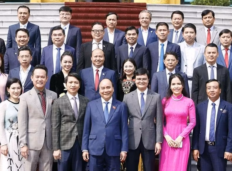 国家主席阮春福与模范青年企业家合影。