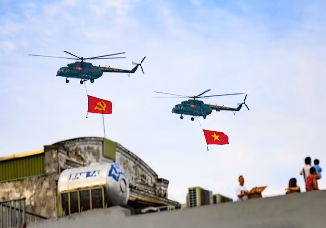 人民空军直升机编队悬挂党旗与国旗飞越河内上空。