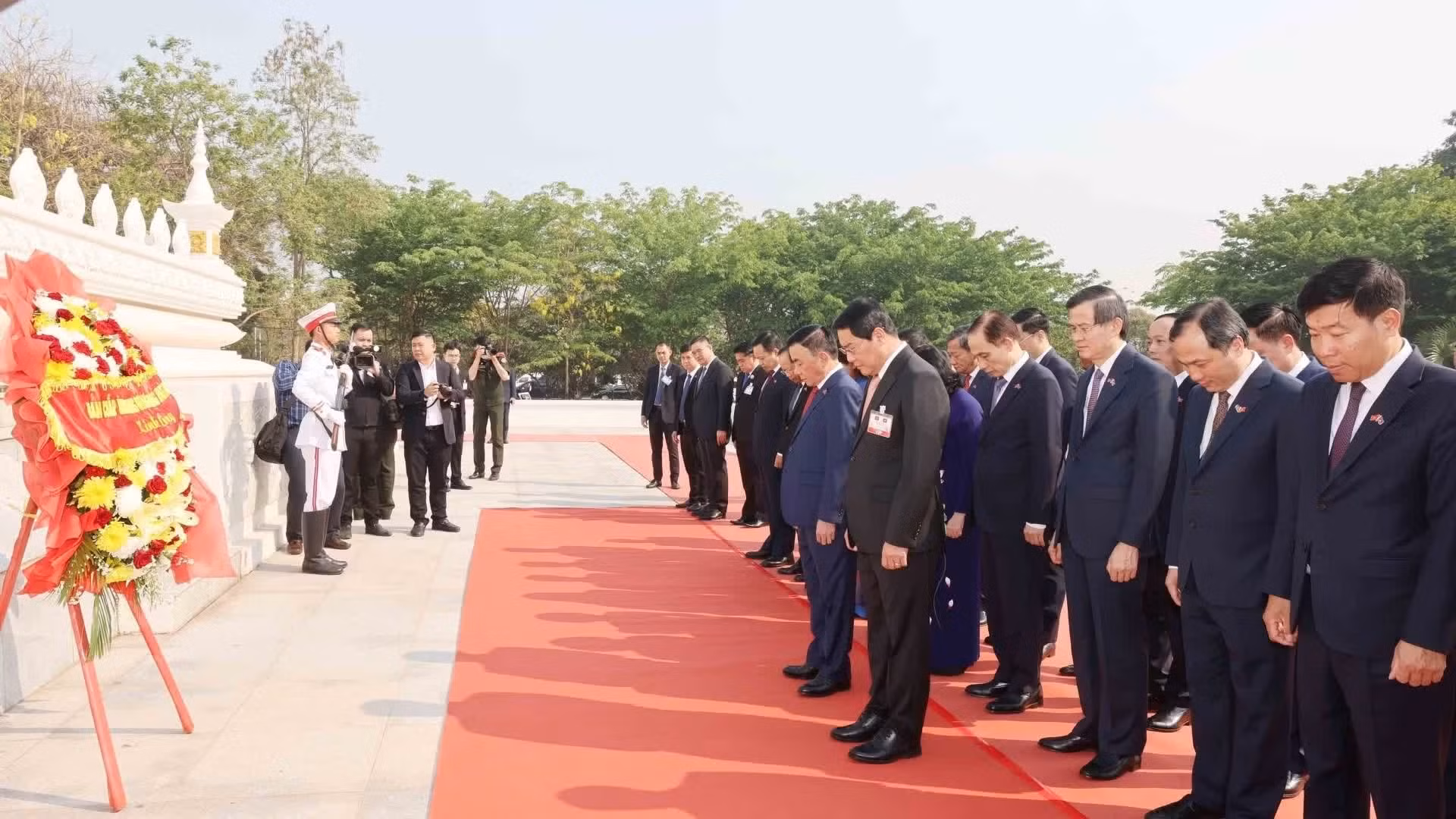 越共中央书记处常务书记陈锦秀及越南高级代表团在万象无名烈士纪念碑敬献花圈，缅怀各位烈士。