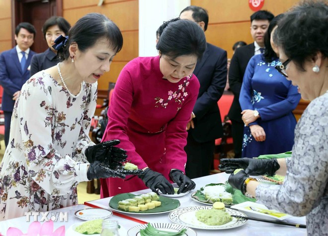 两位夫人一起体验制作河内传统饼点扁米饼。（图片来源：越通社） 