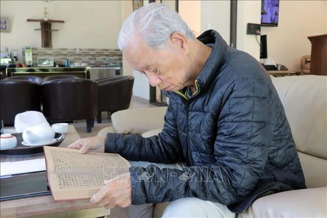 老战地记者严士泰先生翻阅那本遗失近60年的日记，仿佛回到了烽火连天的岁月。（图片来源：越通社）
