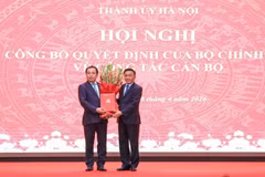 越共中央政治局委员、中央书记处常务书记陈锦秀向新任河内市委书记陈德胜授予决定并送花祝贺。