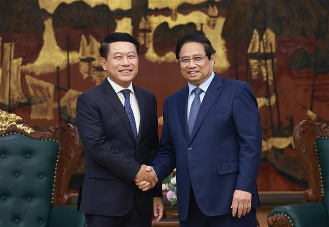 越南政府总理范明正与老挝副总理、人民革命党中央企业改革委员会主任沙伦塞·贡马西合影。