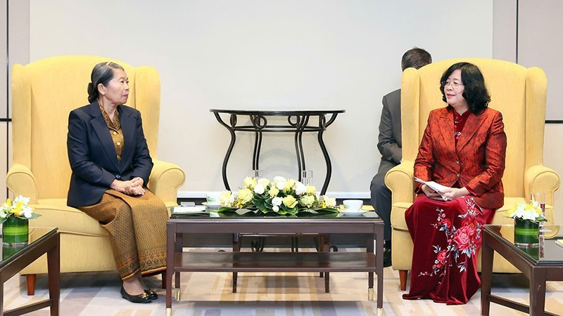 裴氏明怀同志（右）与柬埔寨祖国发展团结阵线国家委员会主席梅森安亲切交谈。