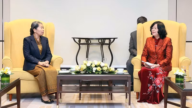 裴氏明怀同志（右）与柬埔寨祖国发展团结阵线国家委员会主席梅森安亲切交谈。