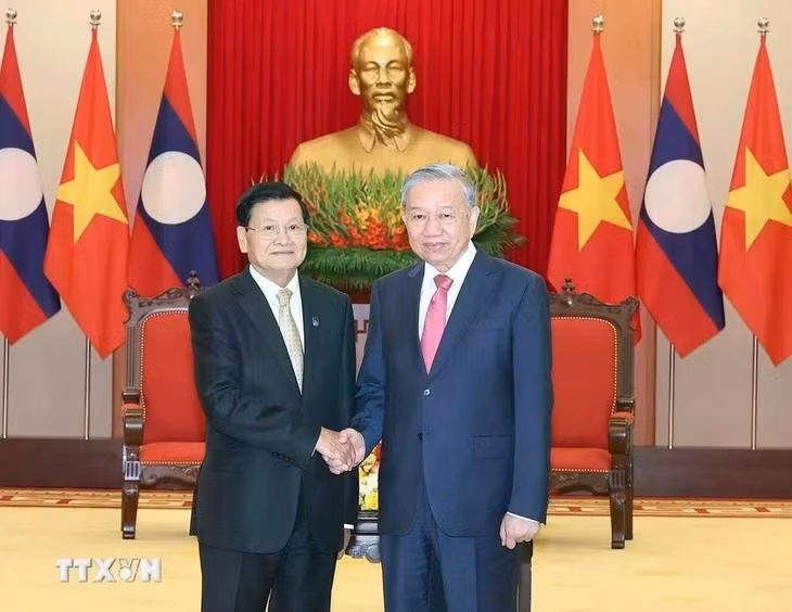 老挝人民革命党中央委员会总书记、老挝人民民主共和国主席通伦·西苏里和越共中央总书记苏林握手。（图片来源：越通社）