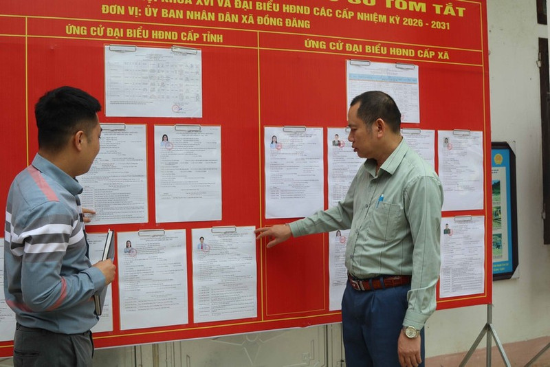 越南谅山省同登边境乡南关村党支部党员，在候选人名单公示处进行宣传与指导。