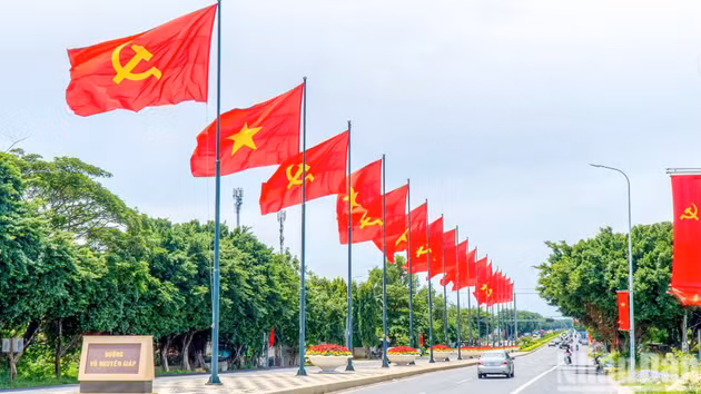 胡志明市悬挂鲜艳的国旗，张贴横幅、宣传画，并布置花卉景观，喜迎9·2国庆节。