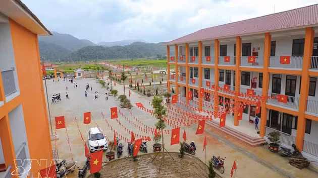 党旗和国旗装饰在教学楼两侧，为奠边省三民小学和初中一贯制寄宿学校校园增添了亮丽色彩。