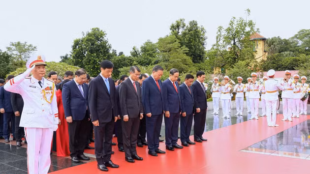 越共中央委员会代表团虔诚鞠躬，缅怀英烈。