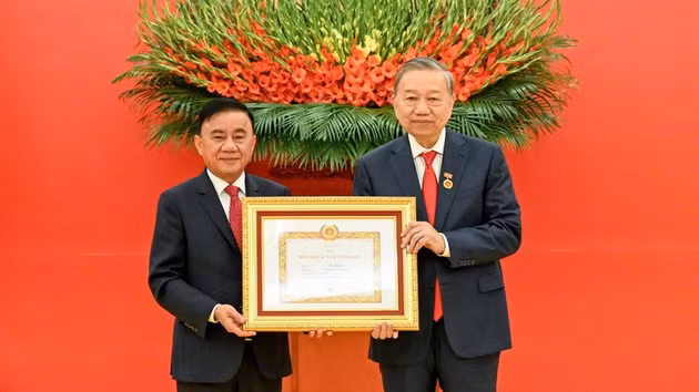 越共中央书记处常务书记陈锦秀向越共中央总书记苏林授予45年党龄纪念章。