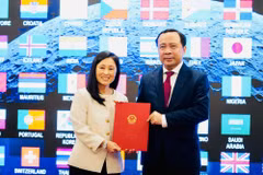 越南科学技术部部长武海军代表越南接收美国驻越南大使詹妮弗·维克斯移交的协议文本。（越南科学技术部供图）