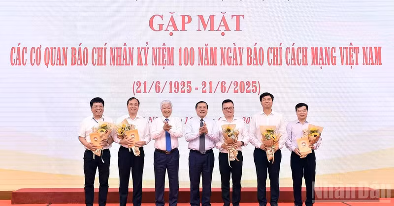 越南祖国阵线中央委员会主席杜文战与越共中央宣教与民运部常务副部长赖春门（左三、左四）在活动中向新闻机构领导代表赠送鲜花。
