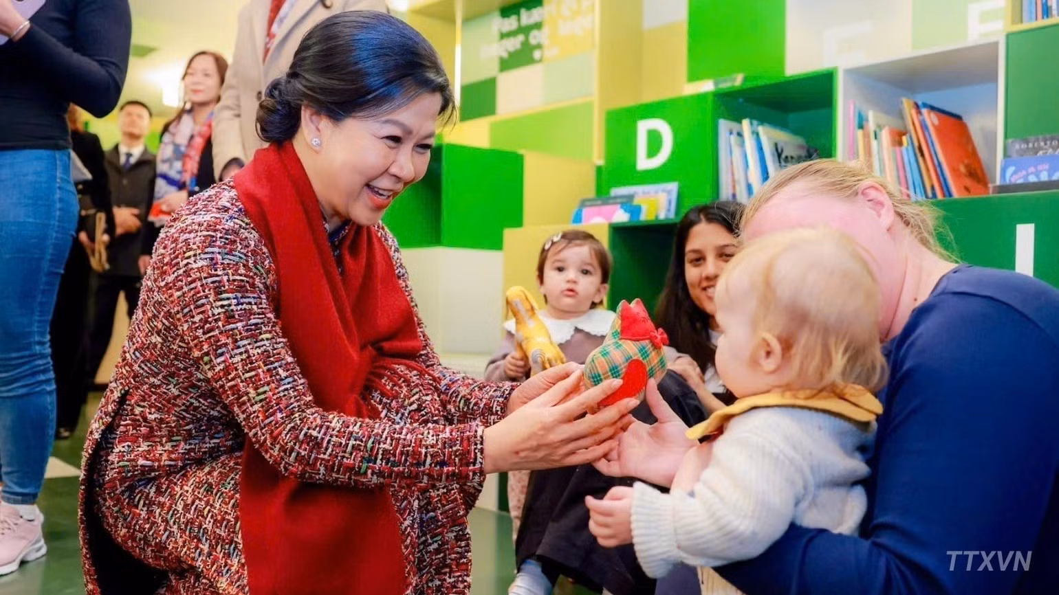 越共中央总书记、国家主席苏林夫人吴芳璃在BIBLIOTEKET Rentemestervej图书馆及社区文化中心与幼儿亲切互动。（图片来源：越通社）