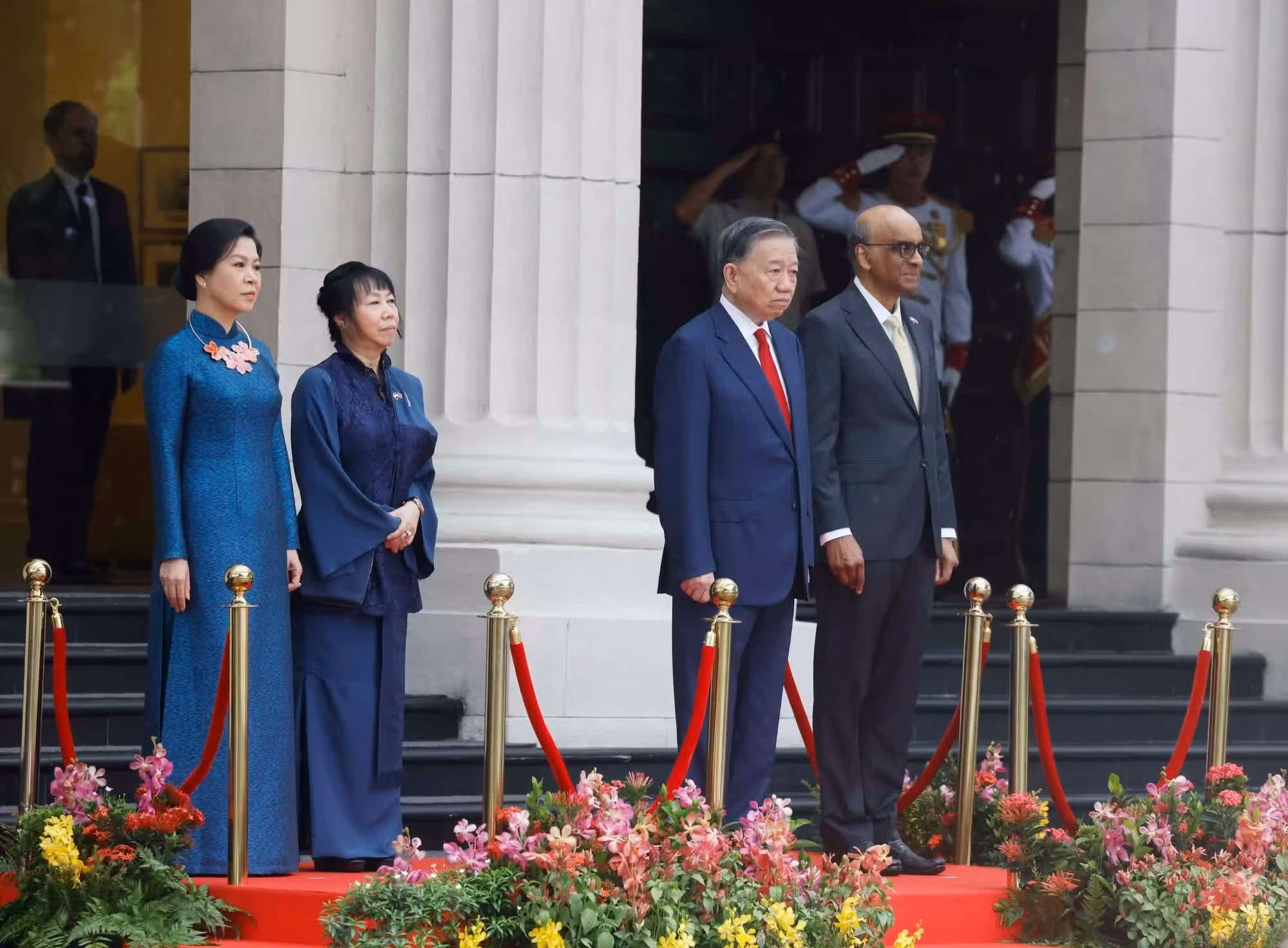 越共中央总书记、国家主席苏林与新加坡总统尚达曼在检阅台上，聆听军乐队奏两国国歌。