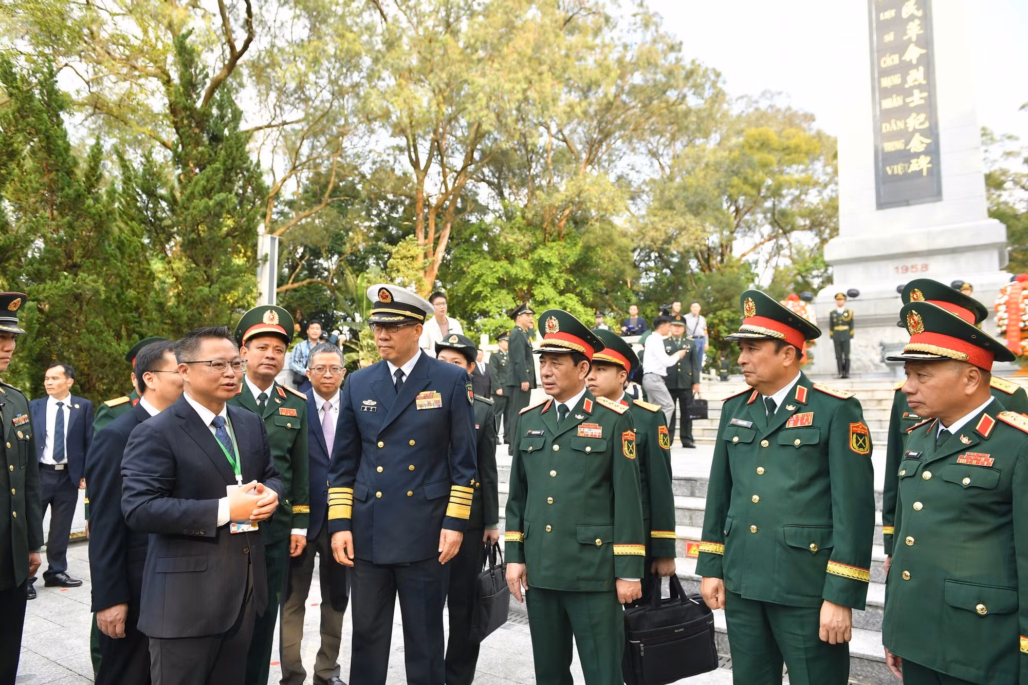 潘文江大将与董军上将以及两国各位代表倾听关于越中人民革命烈士纪念碑的介绍。