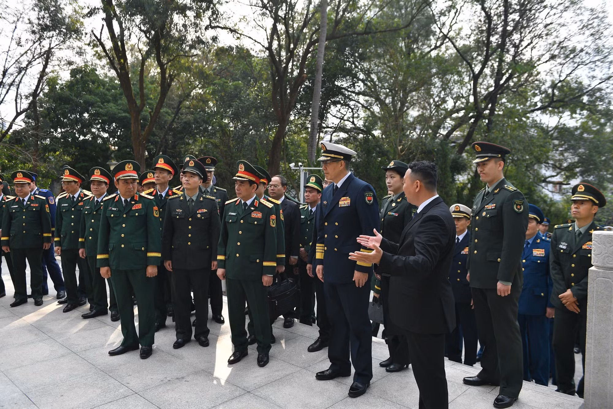 潘文江大将与董军上将以及两国各位代表倾听关于越中人民革命烈士纪念碑的介绍。