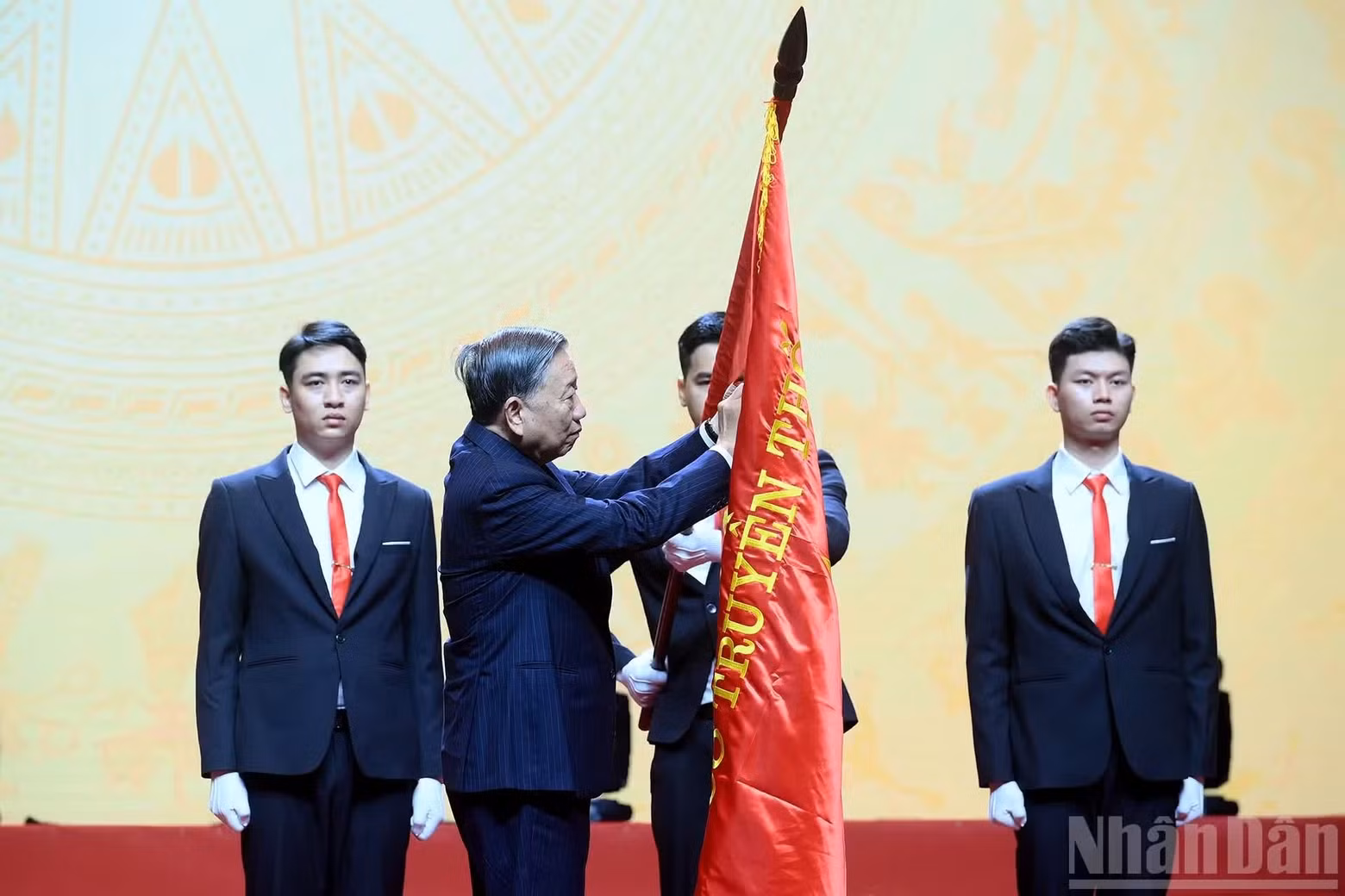 苏林总书记、国家主席将一级劳动勋章佩戴在河内国家大学传统旗上。