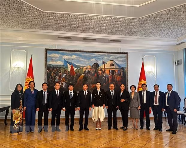 越南国会副主席阮克定（左六）与吉尔吉斯斯坦议会副议长伊萨耶娃（左七）以及双方代表合影。（图片来源：越通社）