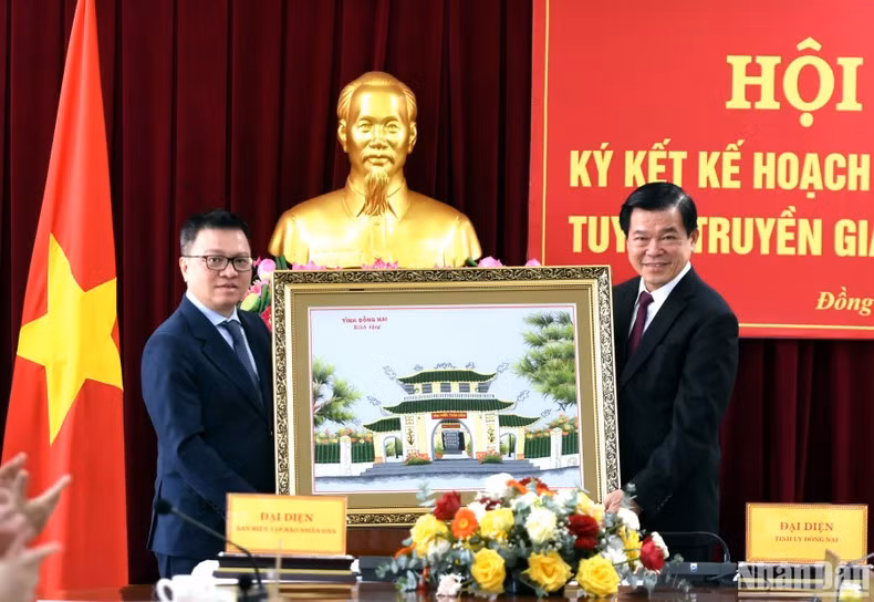 阮鸿领同志向《人民报》社领导赠送纪念品。