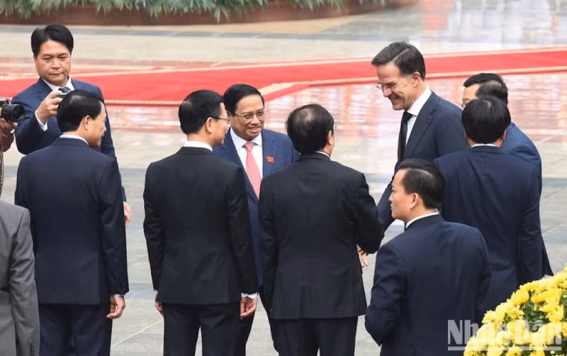 越南政府总理范明正向荷兰首相介绍越南代表团。