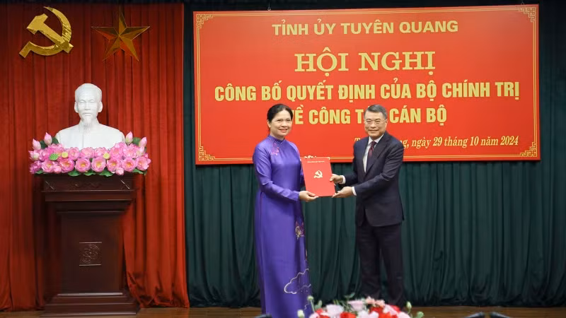 黎明兴同志向何氏娥同志授予决定书。