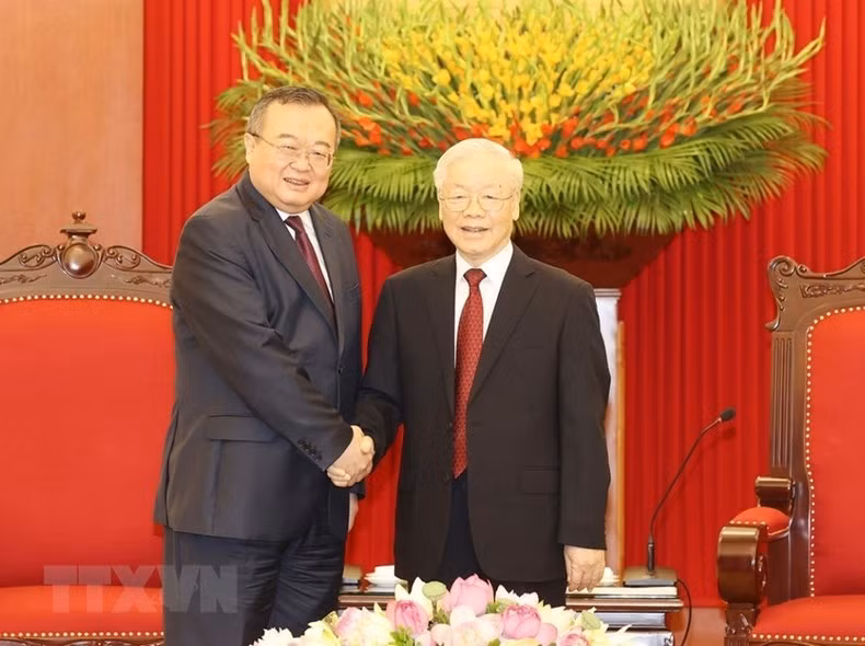 越共中央总书记阮富仲与中共中央委员、中央对外联络部部长刘建超亲切握手。