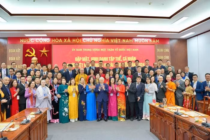 出席表彰会的越南侨胞和各位代表合影。（图片来源：baomoi.com）