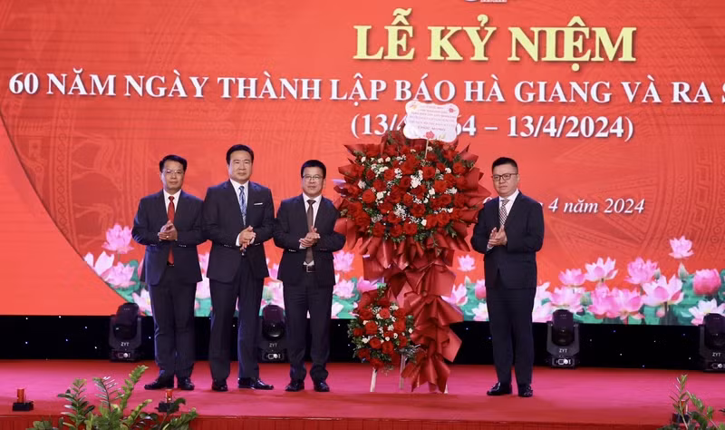 越共中央委员、越南《人民报》社总编辑、中央宣教部副部长、越南新闻工作者协会主席黎国明送鲜花祝贺《河江报》。（庆全 摄）