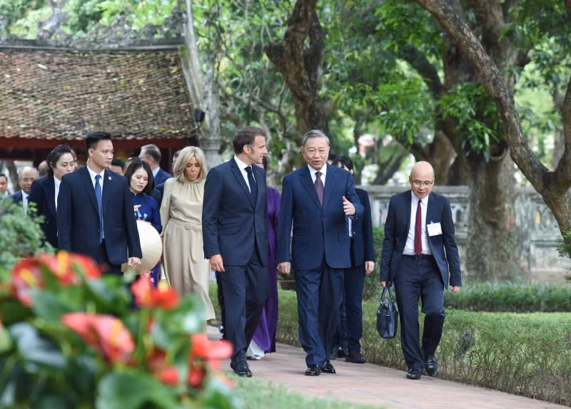 越共中央总书记苏林携夫人吴芳璃和法国总统埃马纽埃尔·马克龙携夫人布丽吉特·马克龙倾听有关文庙-国子监奎文阁的介绍。