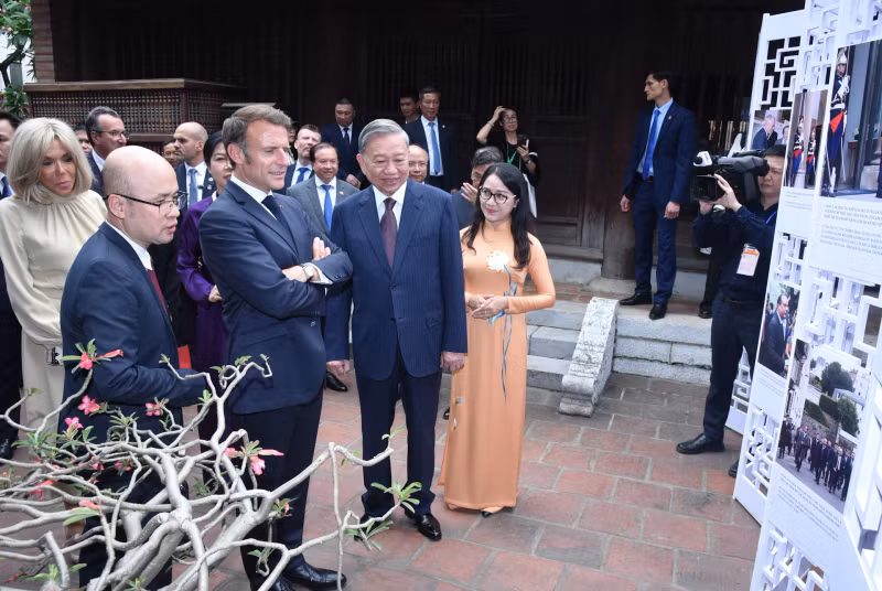 越共中央总书记苏林携夫人吴芳璃和法国总统埃马纽埃尔·马克龙携夫人布丽吉特·马克龙参观越法合作关系的图片展。