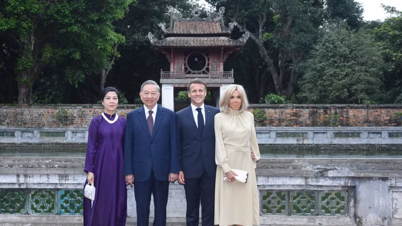 越共中央总书记苏林携夫人吴芳璃和法国总统埃马纽埃尔·马克龙携夫人布丽吉特·马克龙在文庙-国子监里的天光井边合影。
