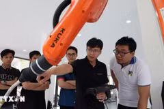 在岘港大学属下岘港理工大学的工业机器人与人工智能应用培训、研究和开发中心测试工业机器人。（图片来源：越通社）