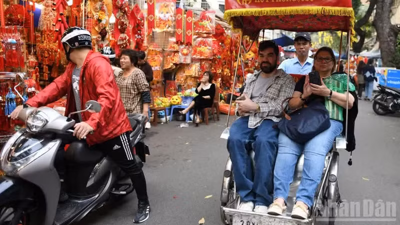 国际游客体验乘坐三轮车环游河内街头。