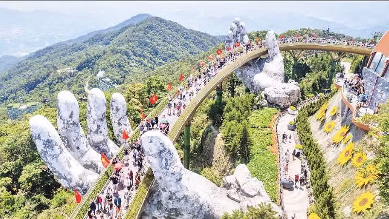 游客欣赏金星红旗飘扬的“金桥”壮丽景观。（潘海松林 摄）