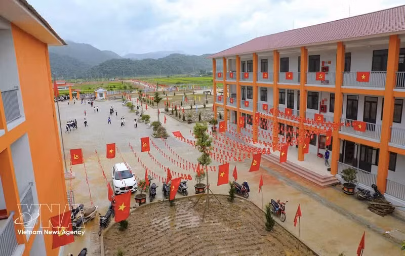 党旗和国旗装饰在教学楼两侧，为奠边省三民小学和初中一贯制寄宿学校校园增添了亮丽色彩。