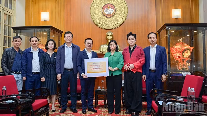 《人民报》社总编辑黎国明移交援助灾区同胞的善款。（宝龙 摄）