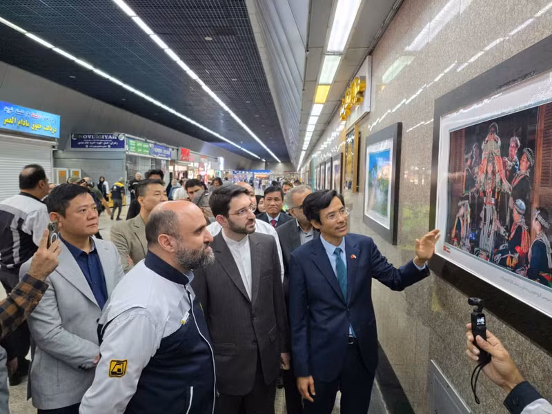 越南驻伊朗大使阮良玉向嘉宾介绍展出照片。（图片来源：越南驻伊朗大使馆）