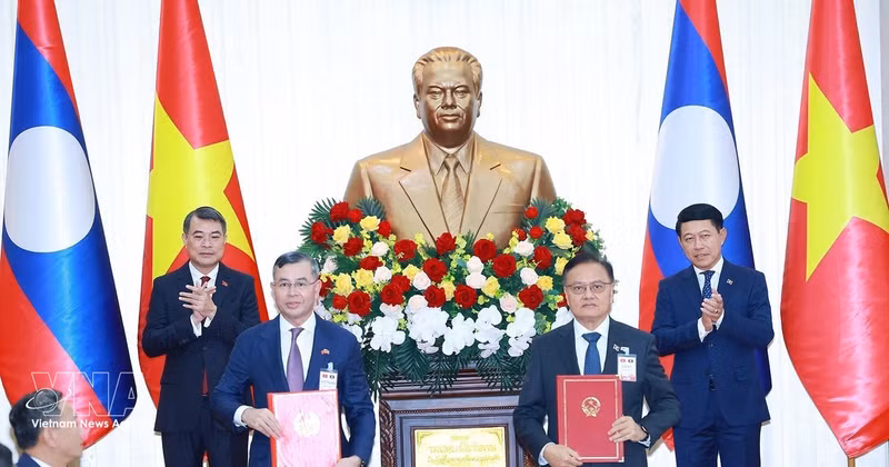 越南政府总理黎明兴与老挝政府总理沙伦赛·贡马西见证两国政府财政领域合作协定的交换仪式。（图片来源：越通社）